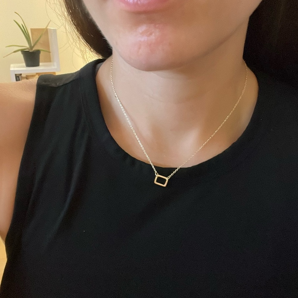 Gold necklace with rectangle pendant.
